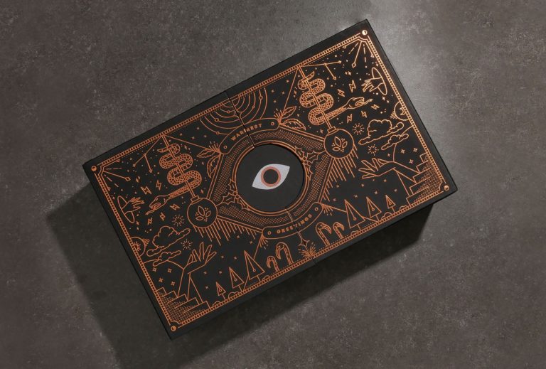 Christmas gift packaging box with intricate pattern in rose gold foil stamping and an eye