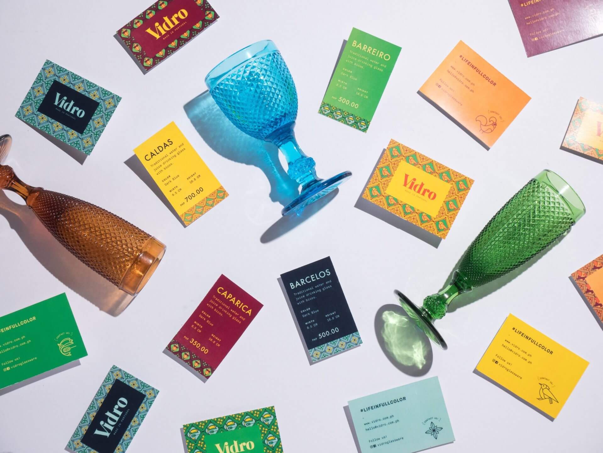 A flatlay of products, product tags, and cards designed for Portuguese glassware brand Vidro