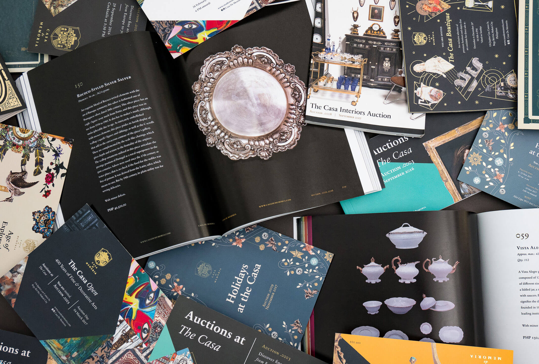 A flatlay of catalog layout spreads for auction house brand Casa de Memoria