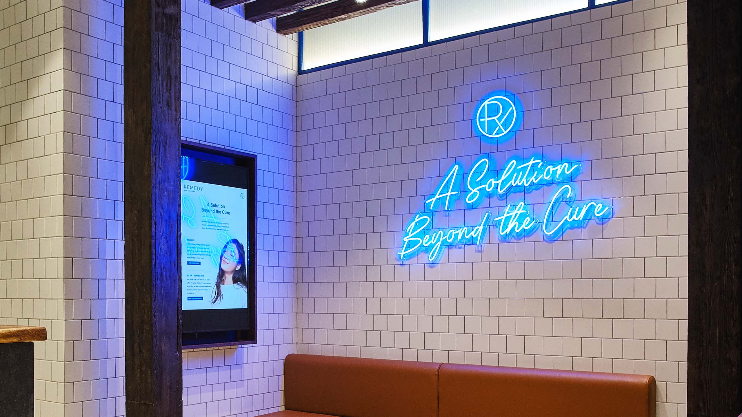 Blue neon sign on a tiled wall for dermatology clinic and brand Remedy Skin Solutions